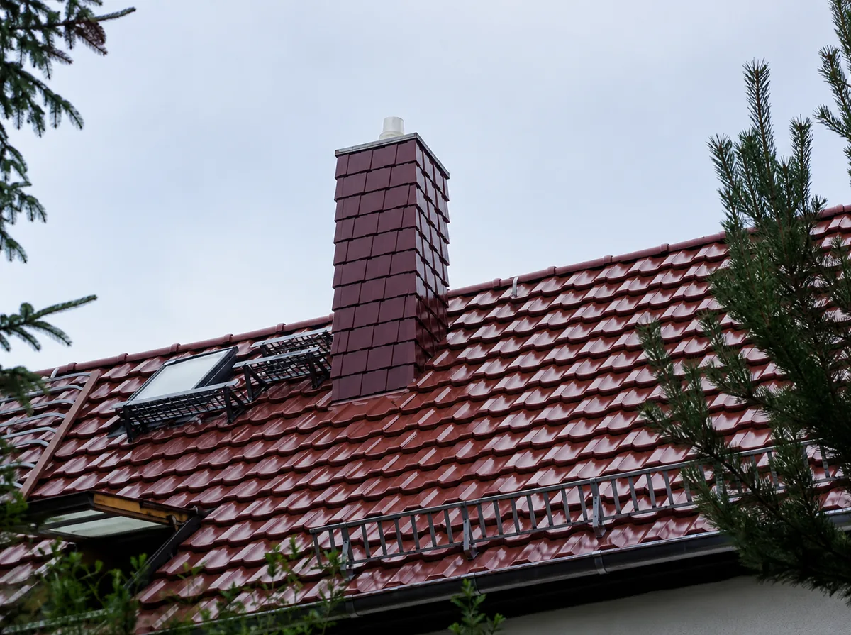 Neu eingedecktes Ziegeldach mit Schornstein und Dachfenster