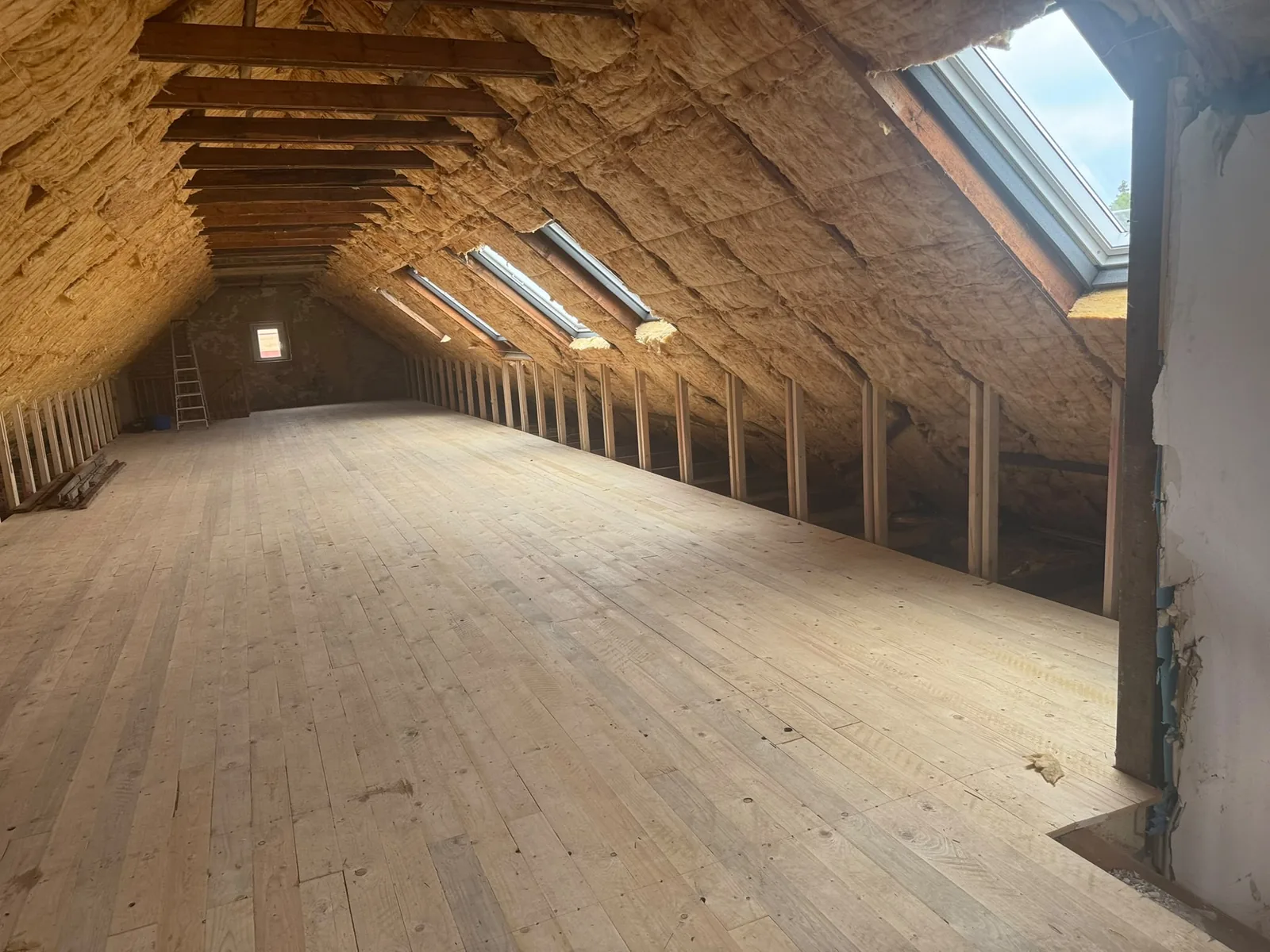 Ausgebauter Dachboden mit sichtbarem Sparrenwerk und neuen Dachfenstern